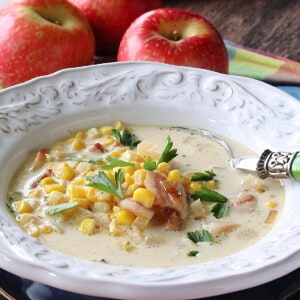A white bowl filled with Apple Corn Chowder with bacon.