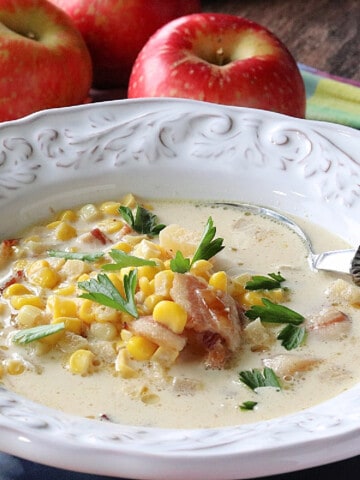 A white bowl filled with Apple Corn Chowder with bacon.