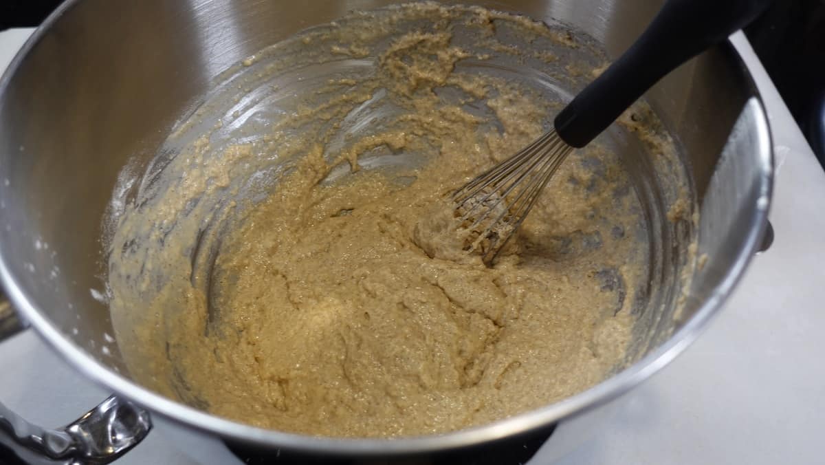 A sticky wet dough in a mixing bowl for making apple cider yeast donuts.
