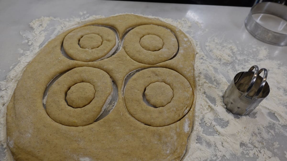 Cutting donuts out of dough for frying.