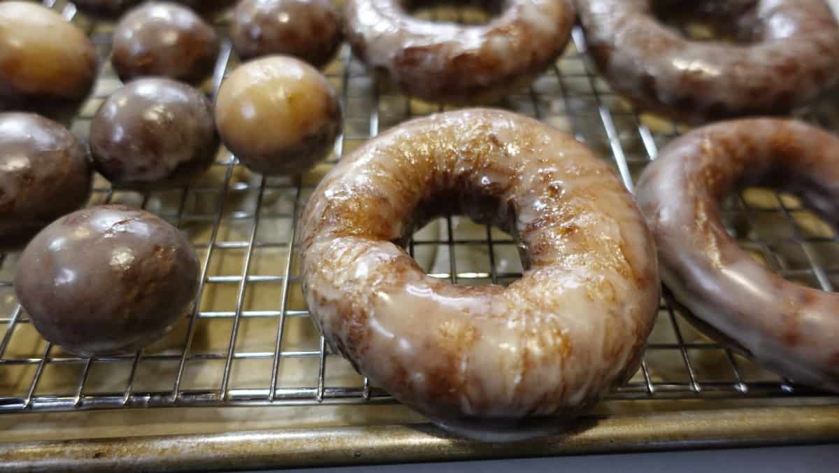 Glazed Apple Cider Donuts drying on a wire rack.