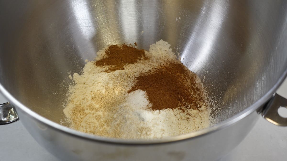 Flour, yeast, cinnamon, and salt in a large bowl for making Glazed Apple Cider Donuts.