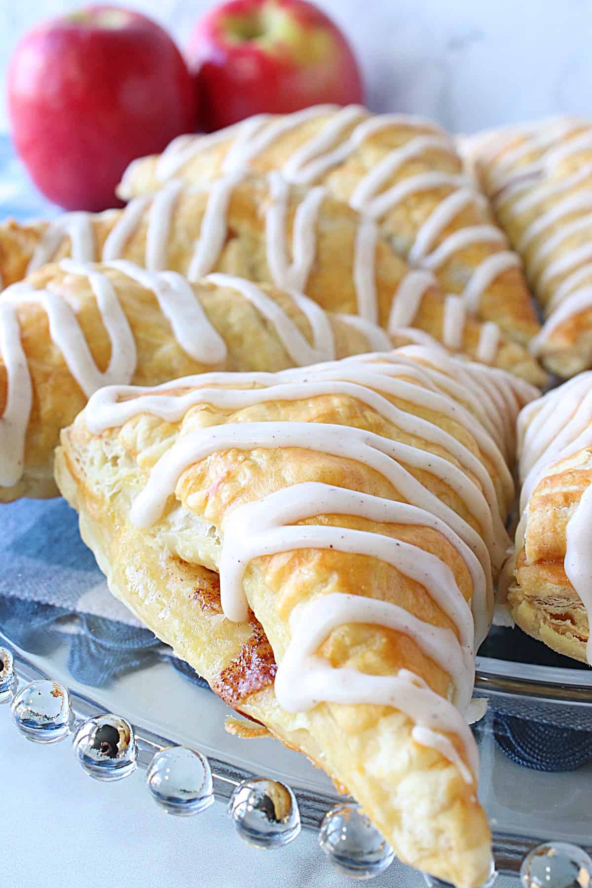 An apple turnover made with puff pastry sheets with a bit of filling oozing out from the side.