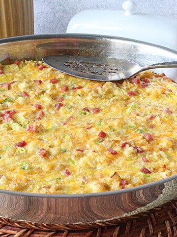 A Ham and Cheese Tater Tot Breakfast Bake in a silver skillet.