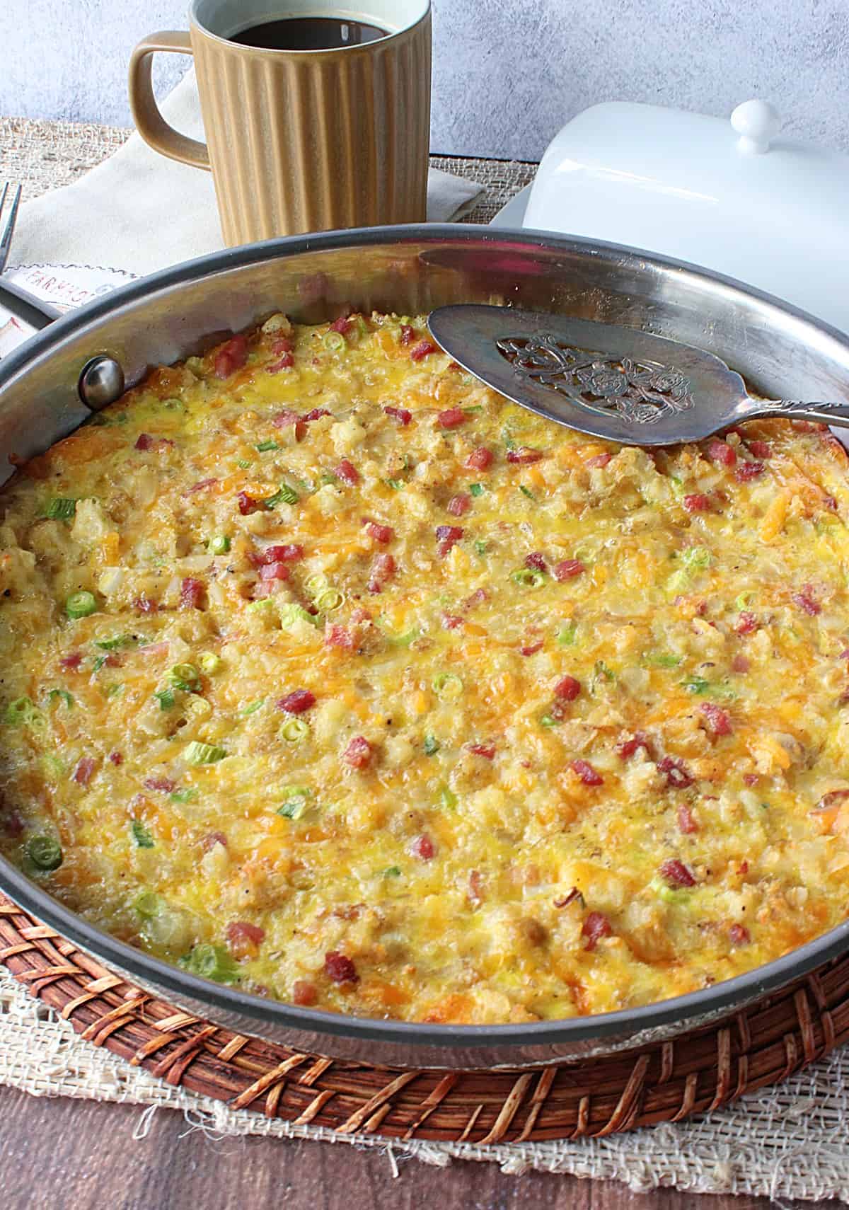 A colorful egg and tater tot frittata with ham, cheese, and scallions.