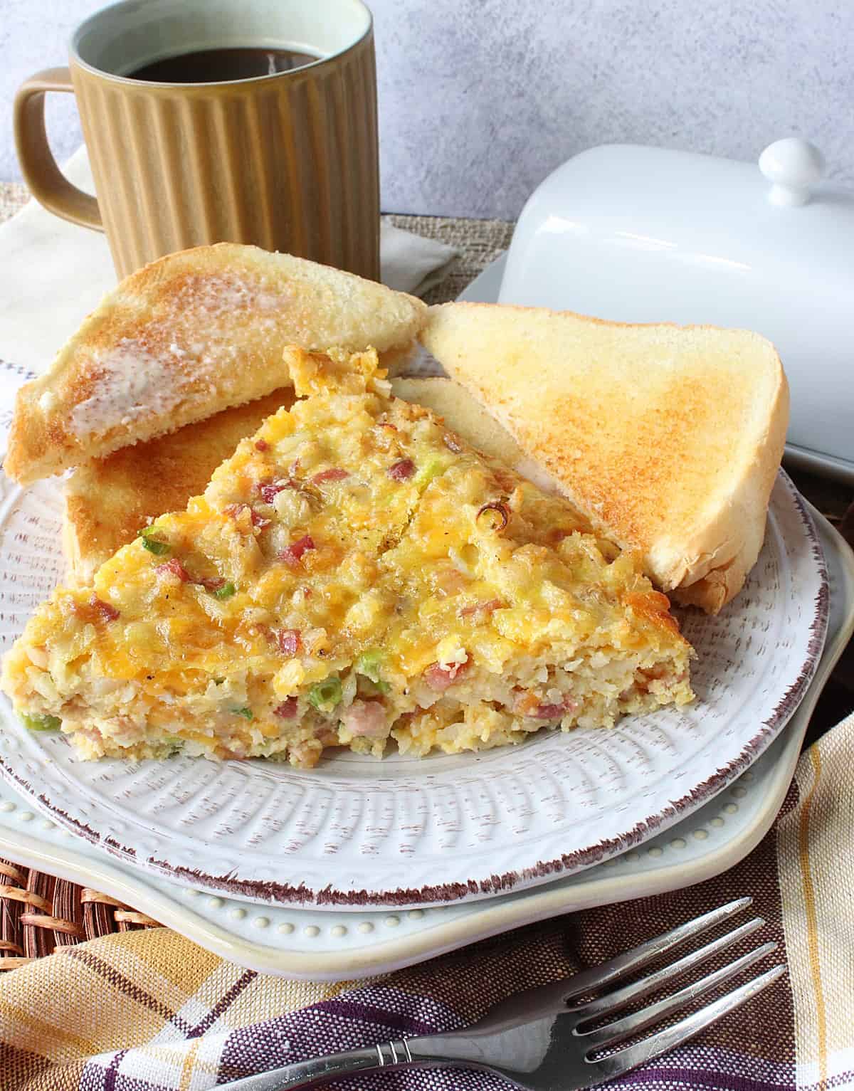 A serving of Ham and Cheese Tater Tot Breakfast Frittata on a plate with toast.