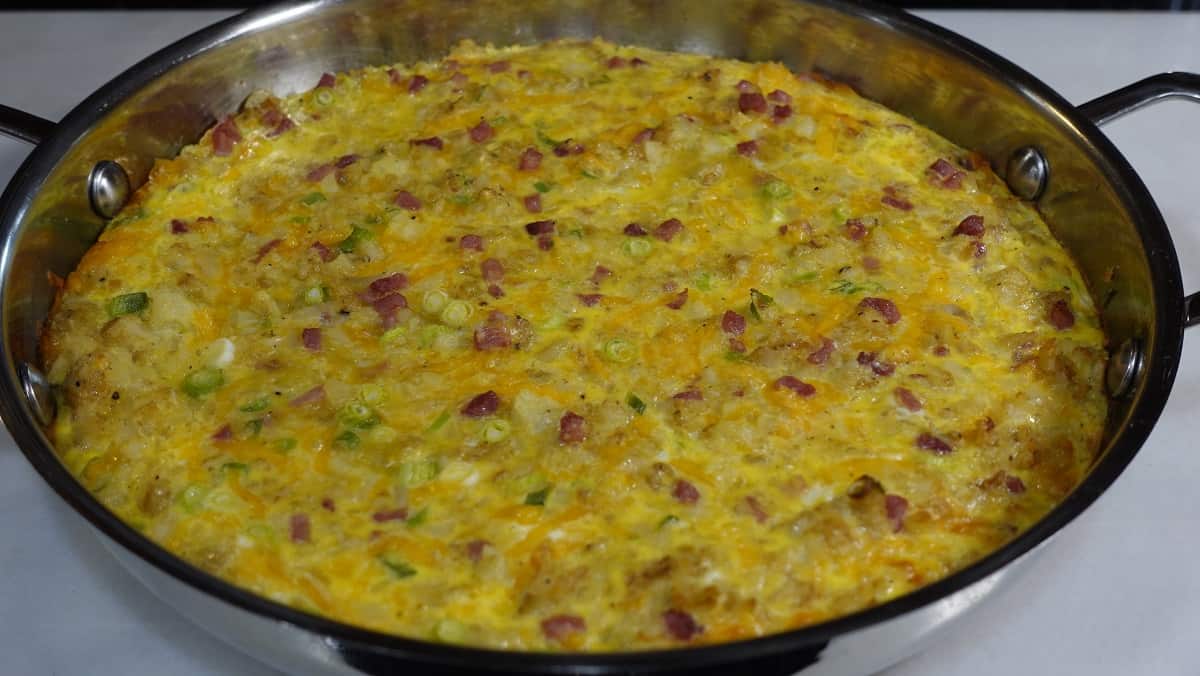 A baked Ham and Cheese Tater Tot Frittata in a skillet.