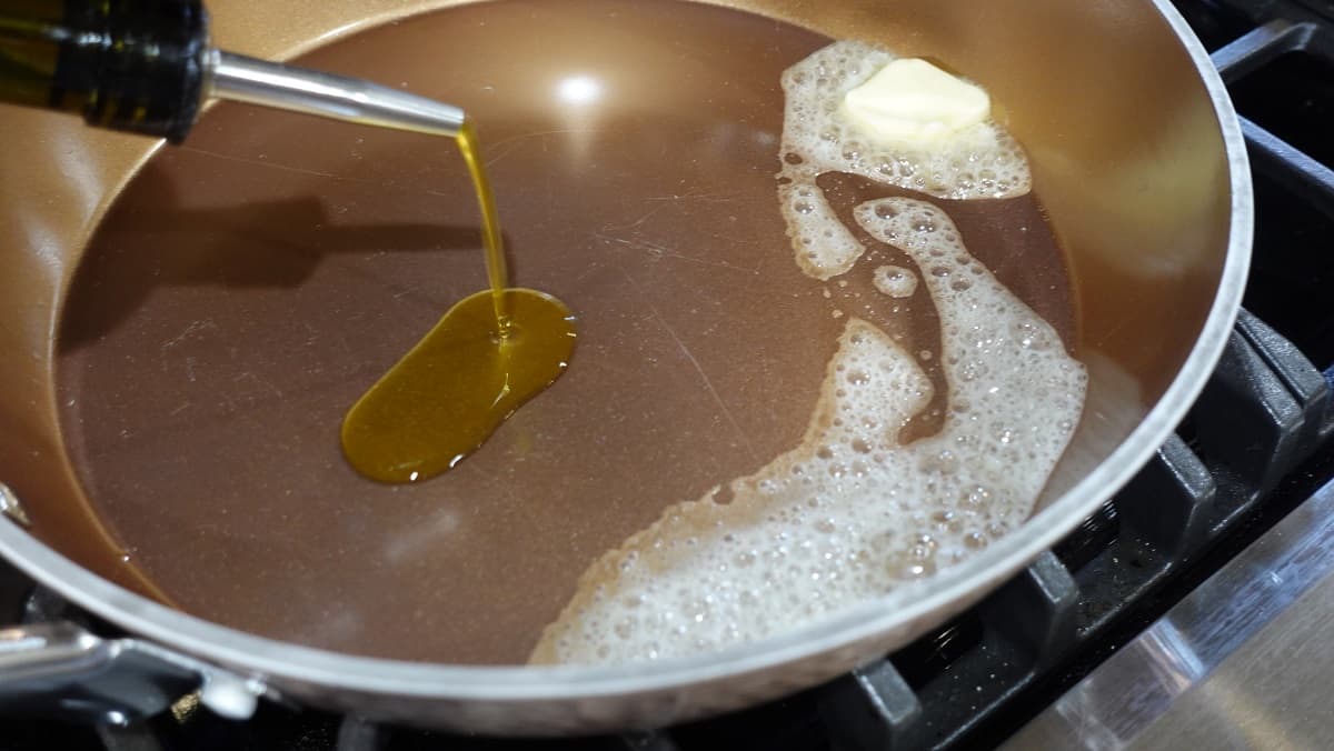 Melted butter and olive oil in a large skillet on the stove.