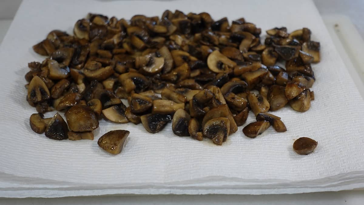 Sauteed mushrooms cooling on paper towels.