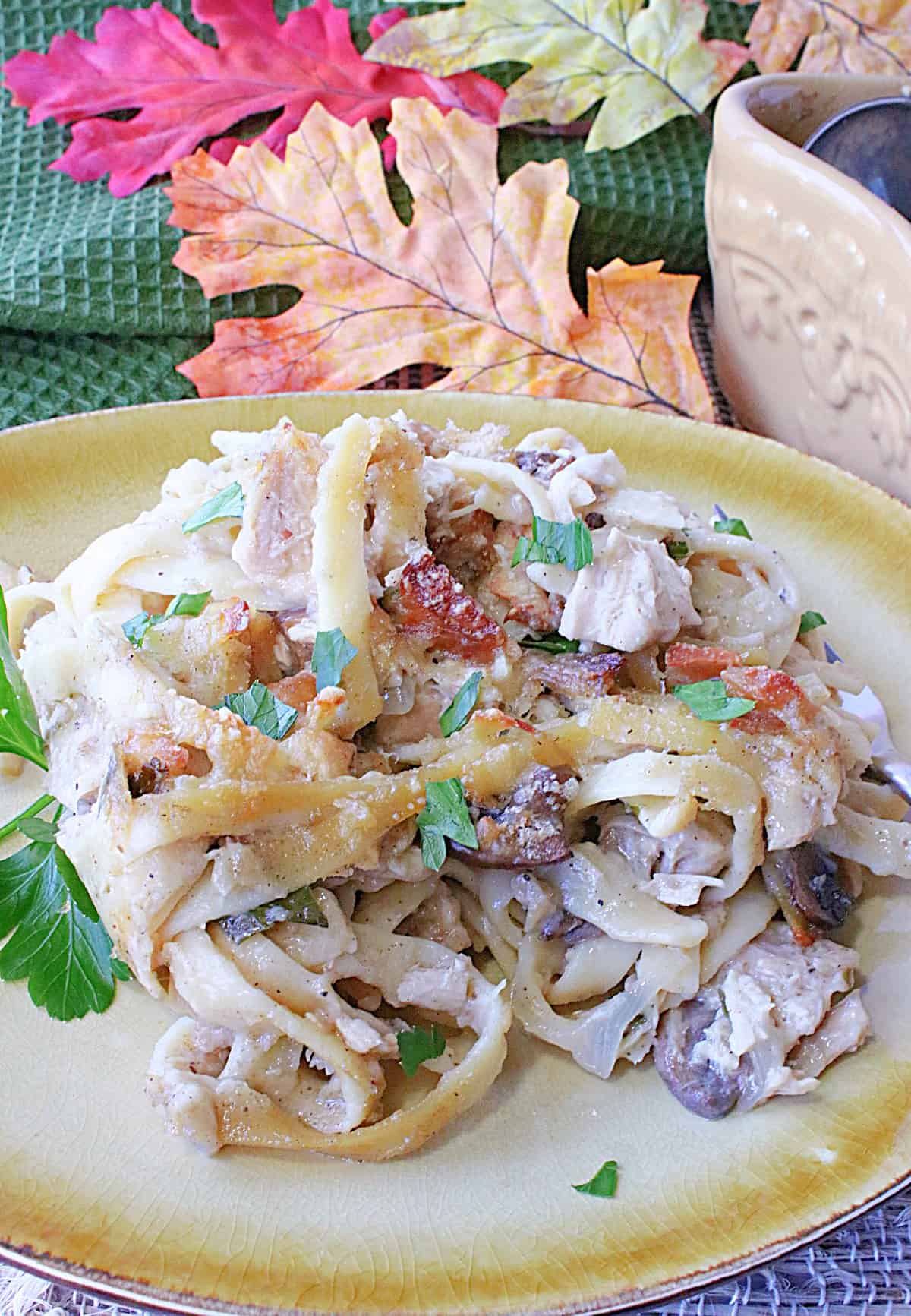 A serving of creamy Leftover Turkey with Linguine (Turkey Tetrazzini) on a plate with parsley.
