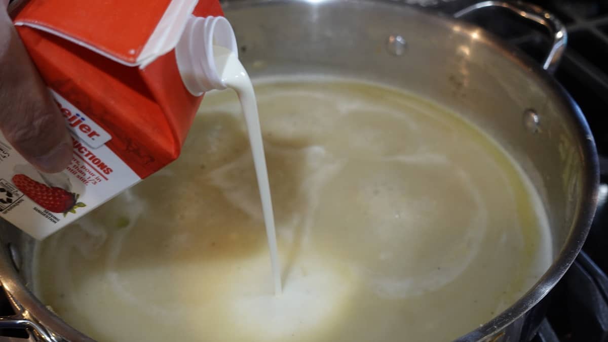 Cream being added to a skillet.