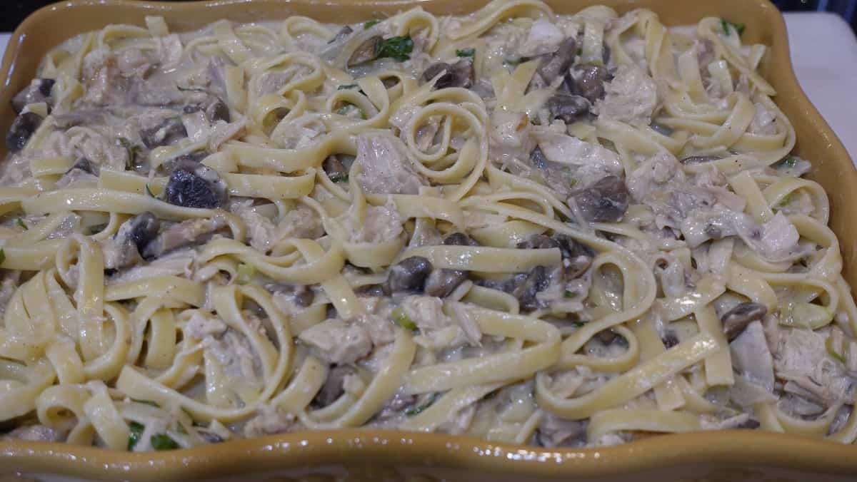 Turkey tetrazzini added to a casserole dish ready for baking.