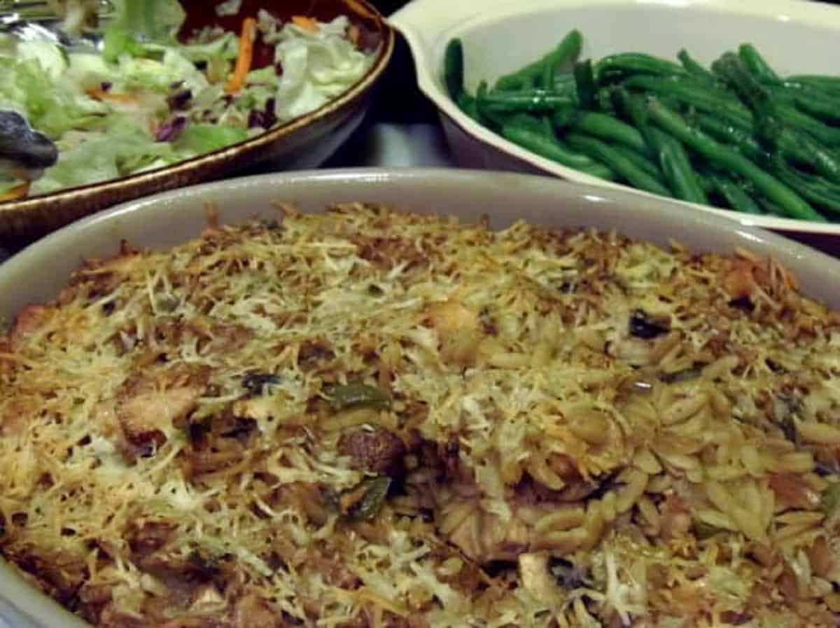 A chicken, orzo and mushroom casserole in a casserole dish ready to serve.