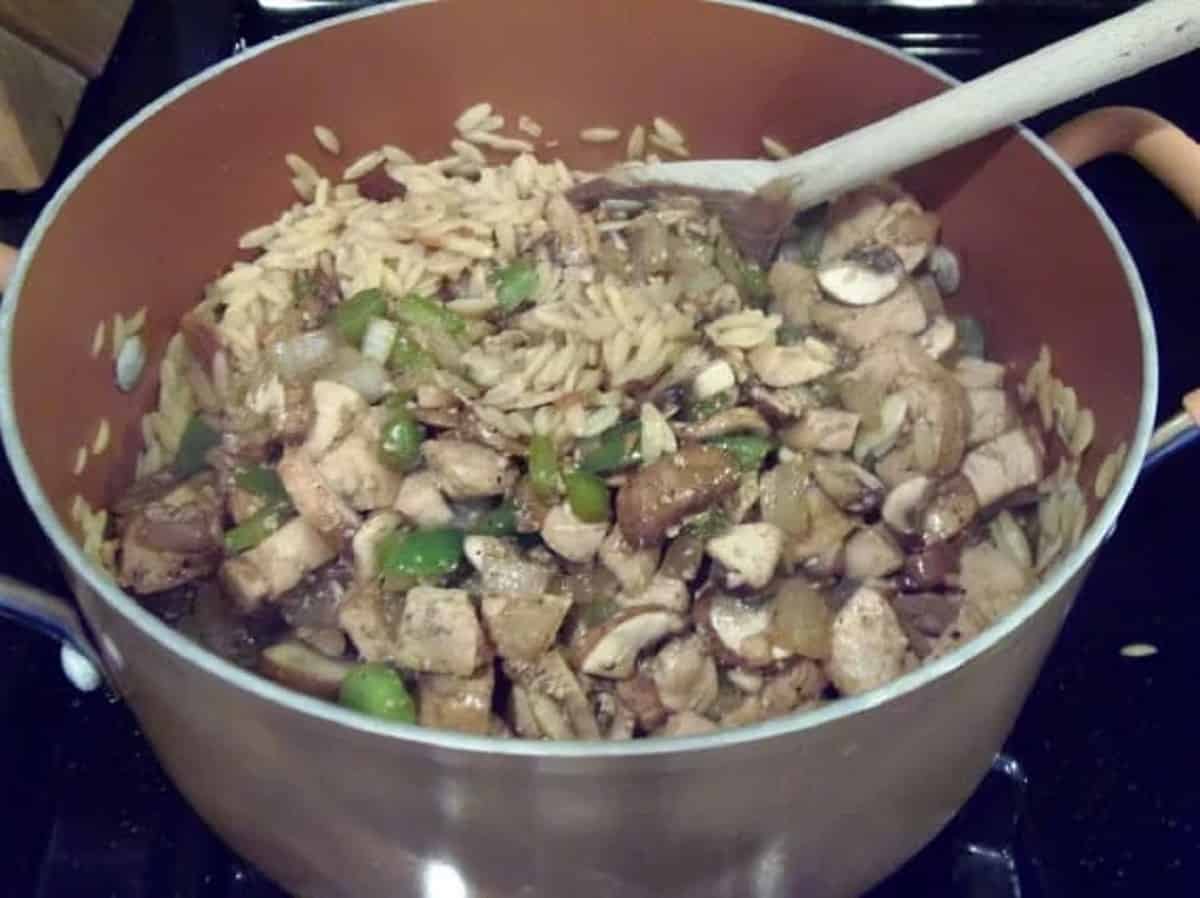 Chicken, mushrooms, green pepper, and onion in a large pot.