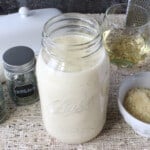 A mason jar filled with Homemade White Wine Alfredo Sauce.