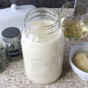 A mason jar filled with Homemade White Wine Alfredo Sauce.