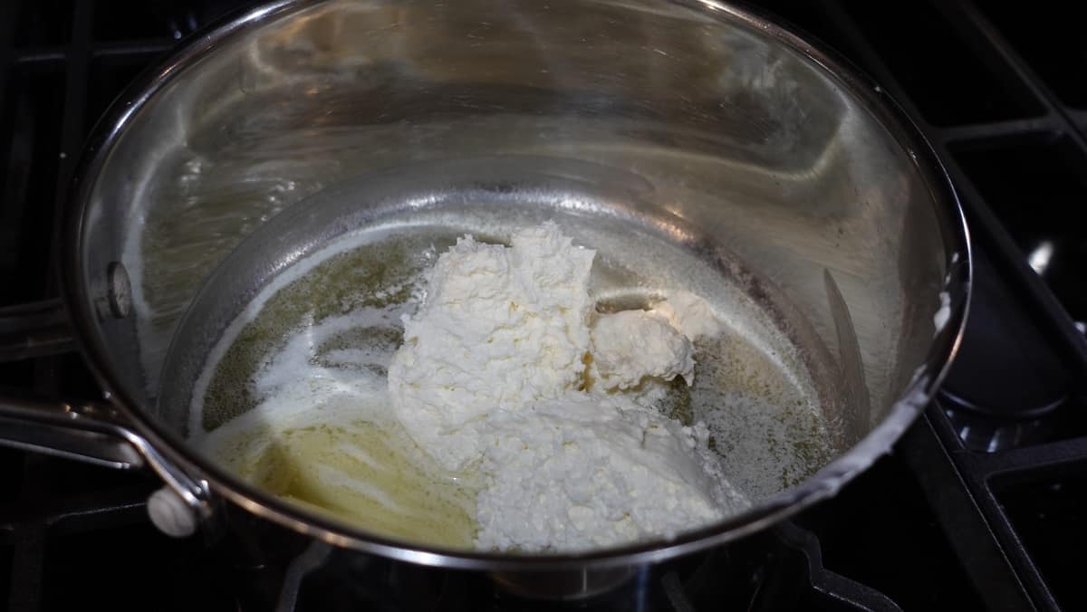 Melted butter and whipped cream cheese in a saucepan.