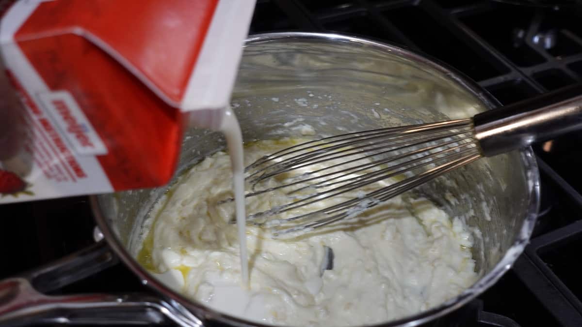 Heavy cream being added to an Alfredo sauce.