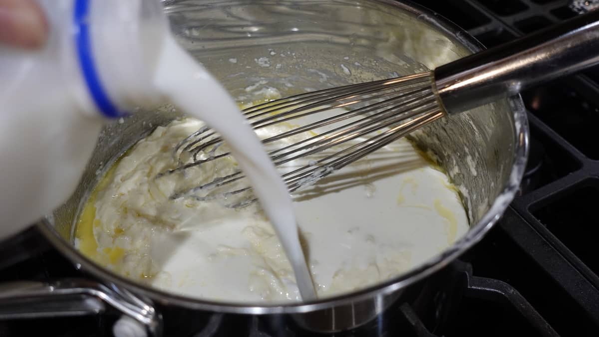 Milk being added to a Homemade Alfredo Sauce.