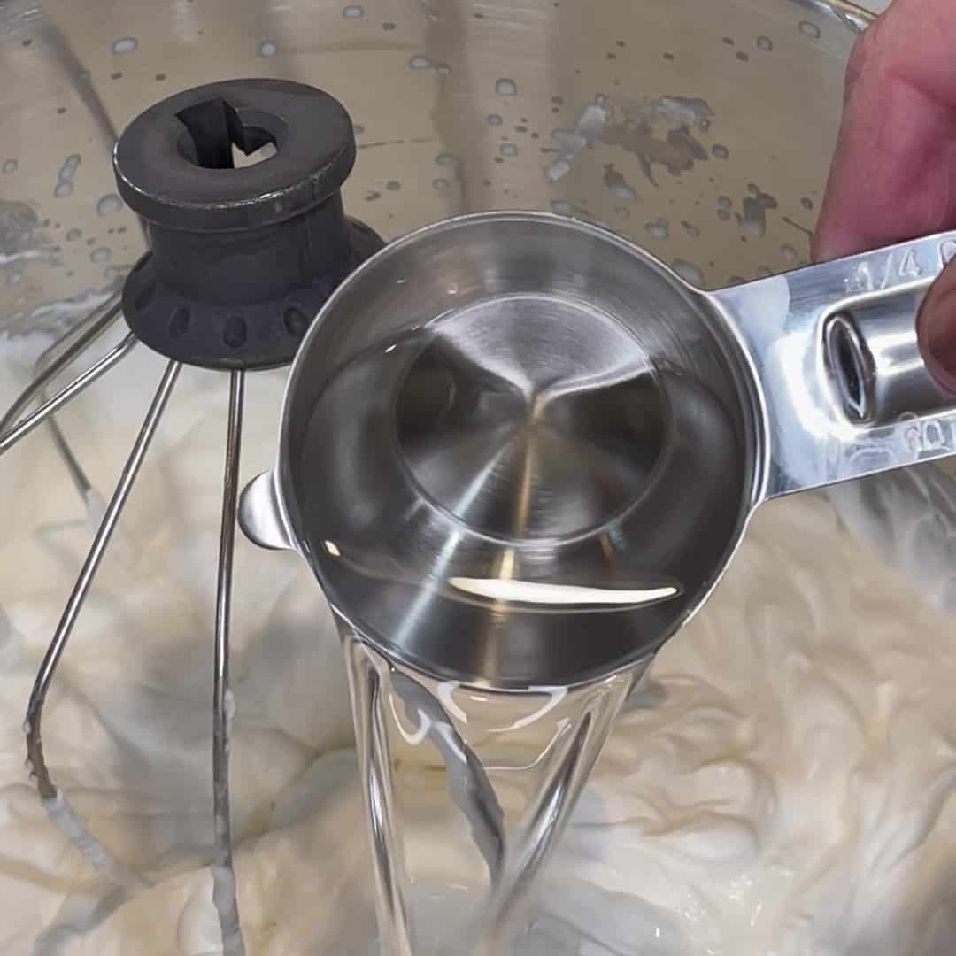 Peppermint schnapps being added to no-churn ice cream.