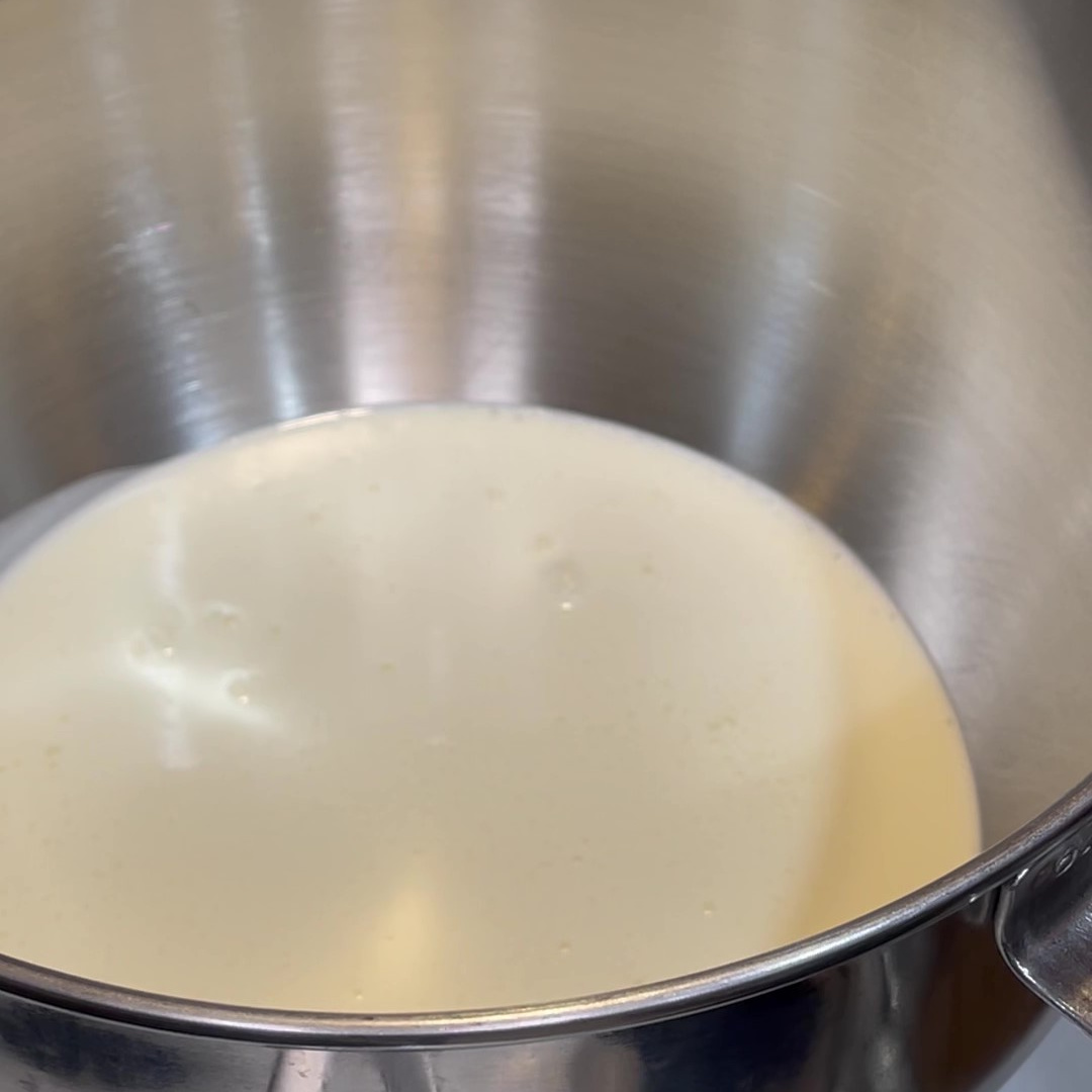 Heavy cream in a silver stand mixer bowl.