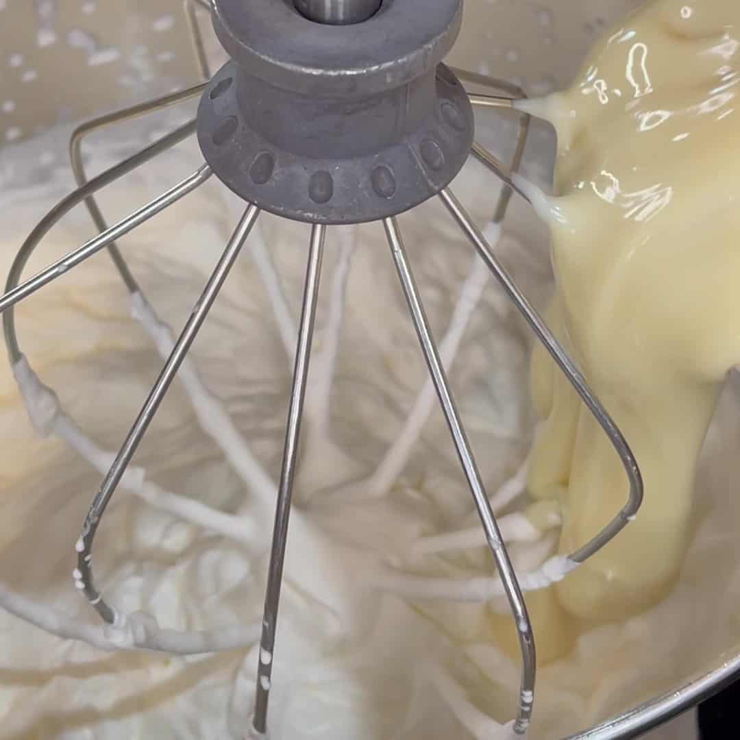 Sweetened condensed milk being added to whipped cream.