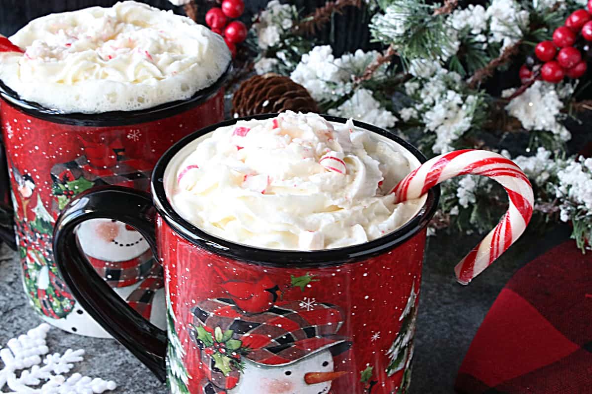 Whipped cream in a cute snowman mug with peppermint on top.