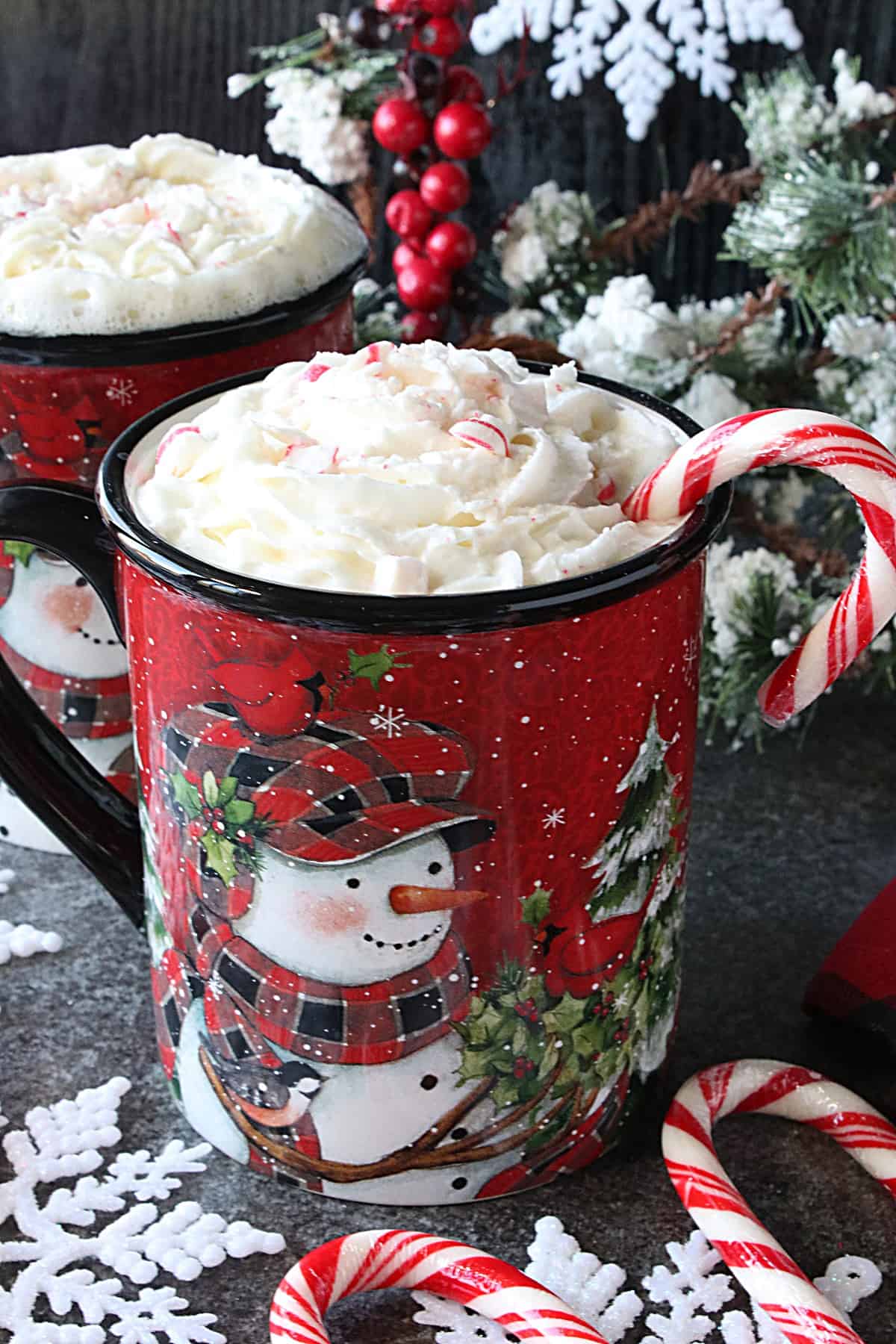 Cute red snowman mug filled with White Hot Chocolate with Peppermint and whipped cream.