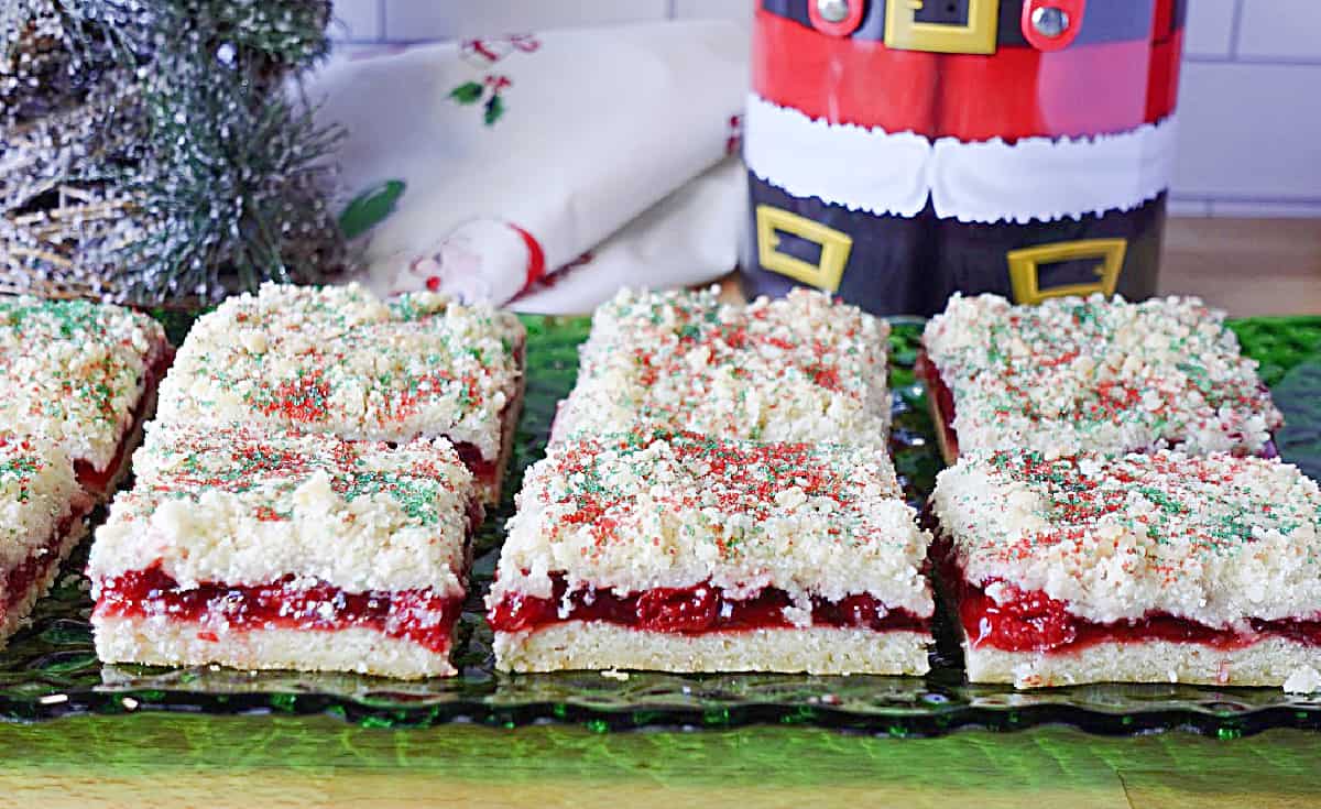 A green glass plate filled with pretty cherry filled pastry for Christmas.