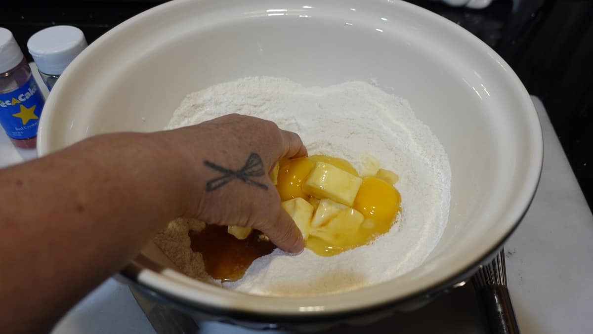 A hand in a bowl mixing the ingredients for Kringle Kuchen.