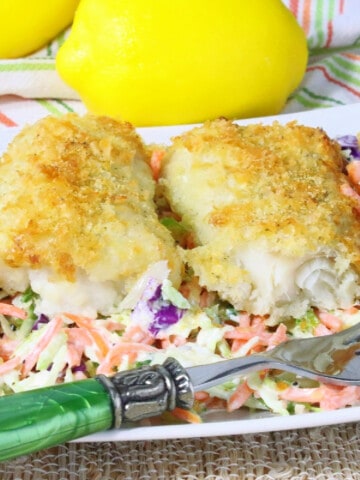 Three pieces of Potato Crusted Cod Fillets on a white plate with a fork.