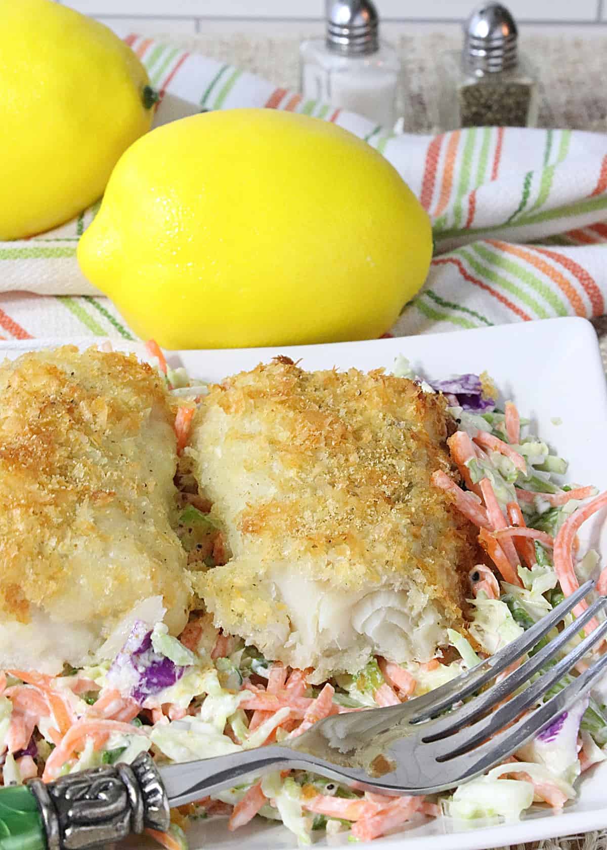 A colorful plate of Potato Crusted Cod on a bed of vibrant coleslaw.