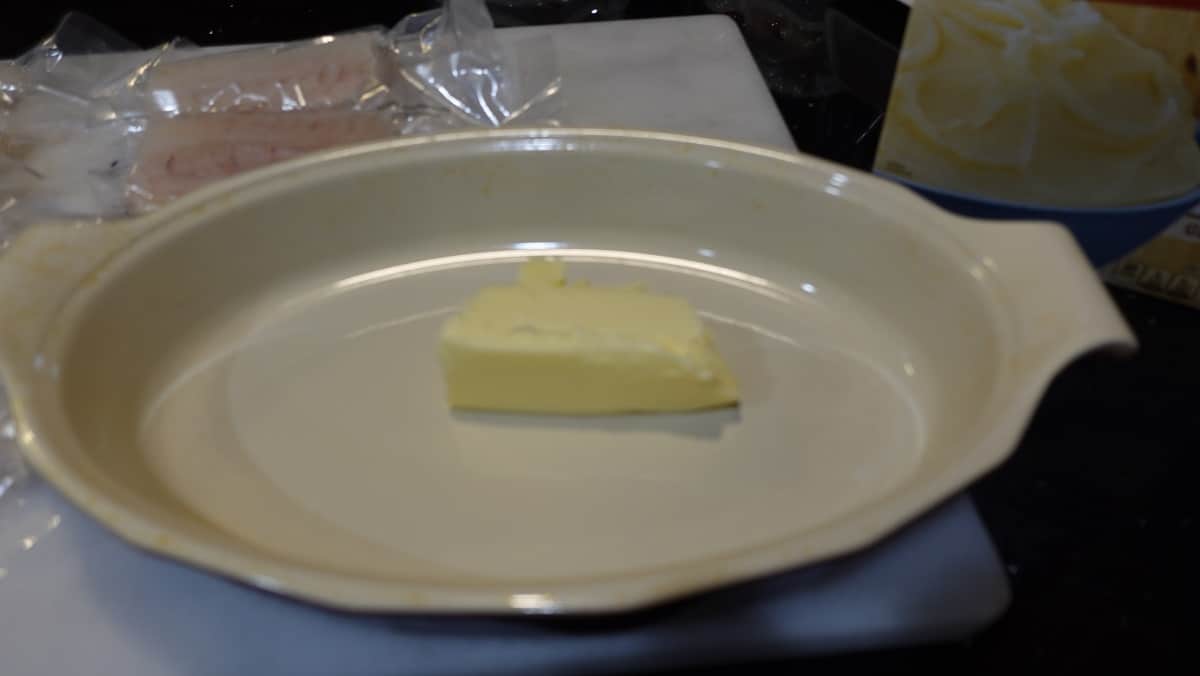 A stick of butter in a shallow dish.