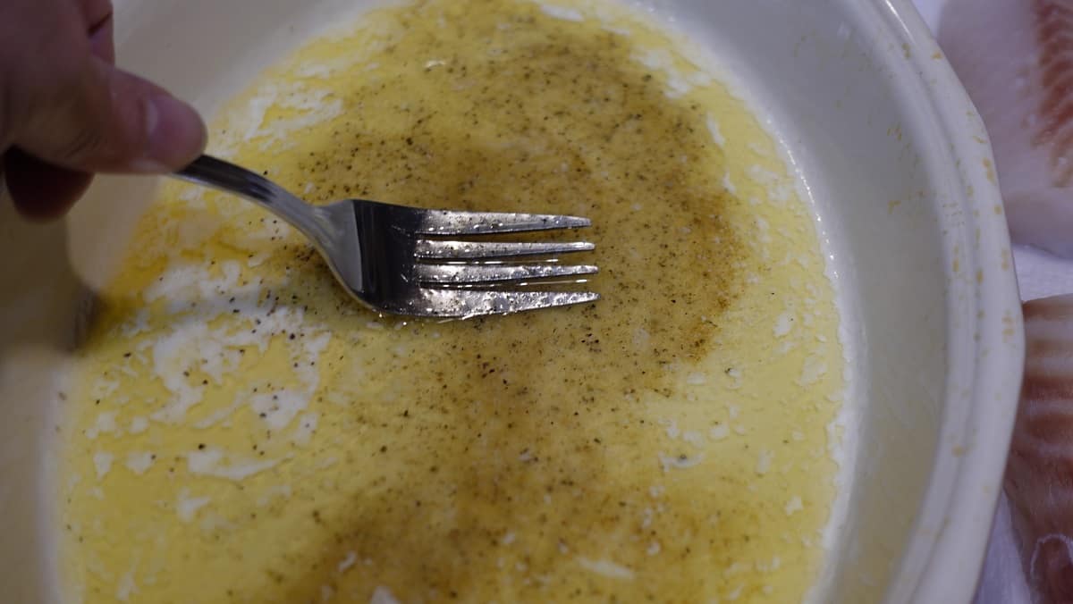 Melted butter being mixed with seasoning.