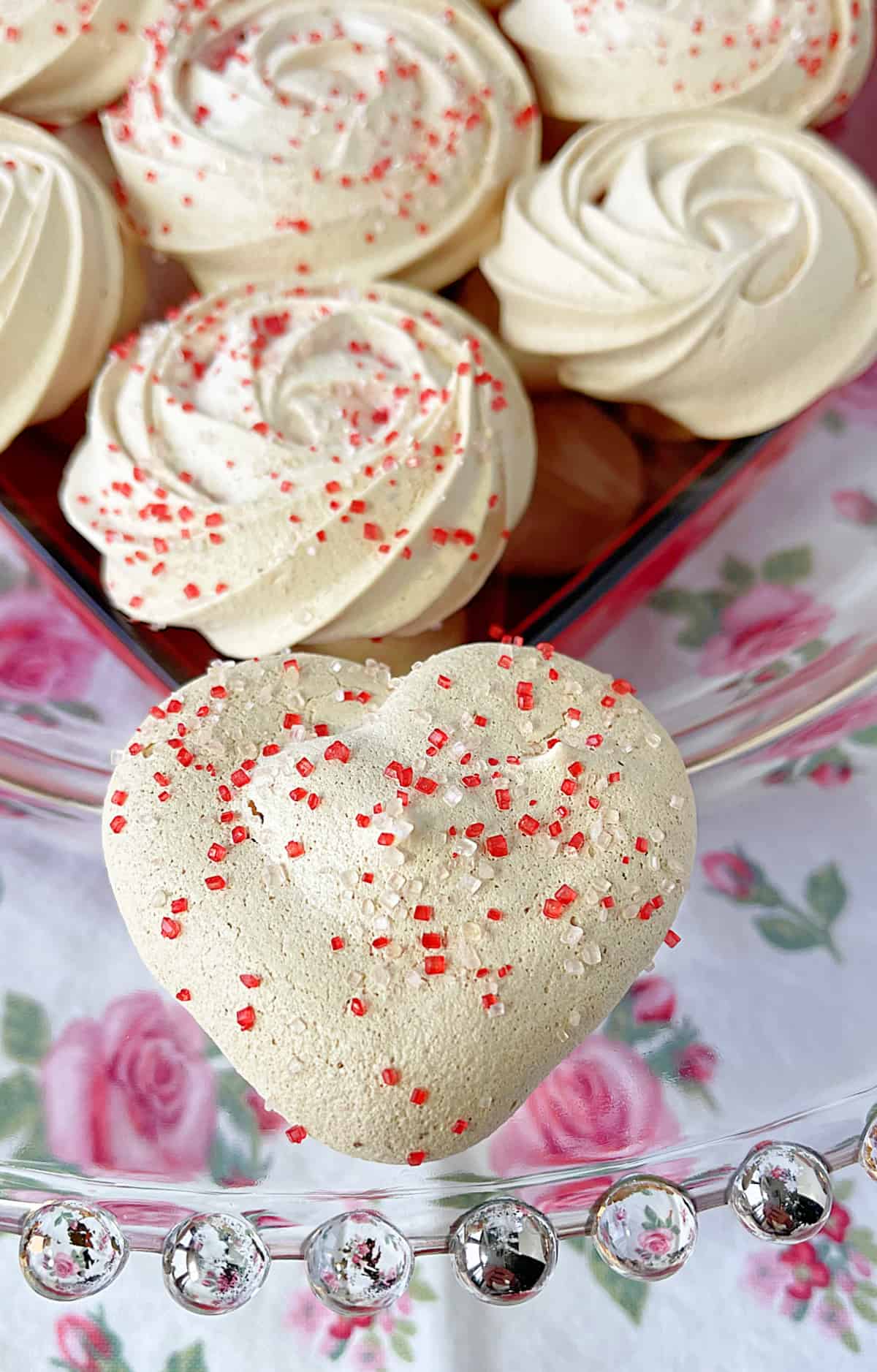A closeup of an Almond Meringue Heart with colored sugar sprinkles.