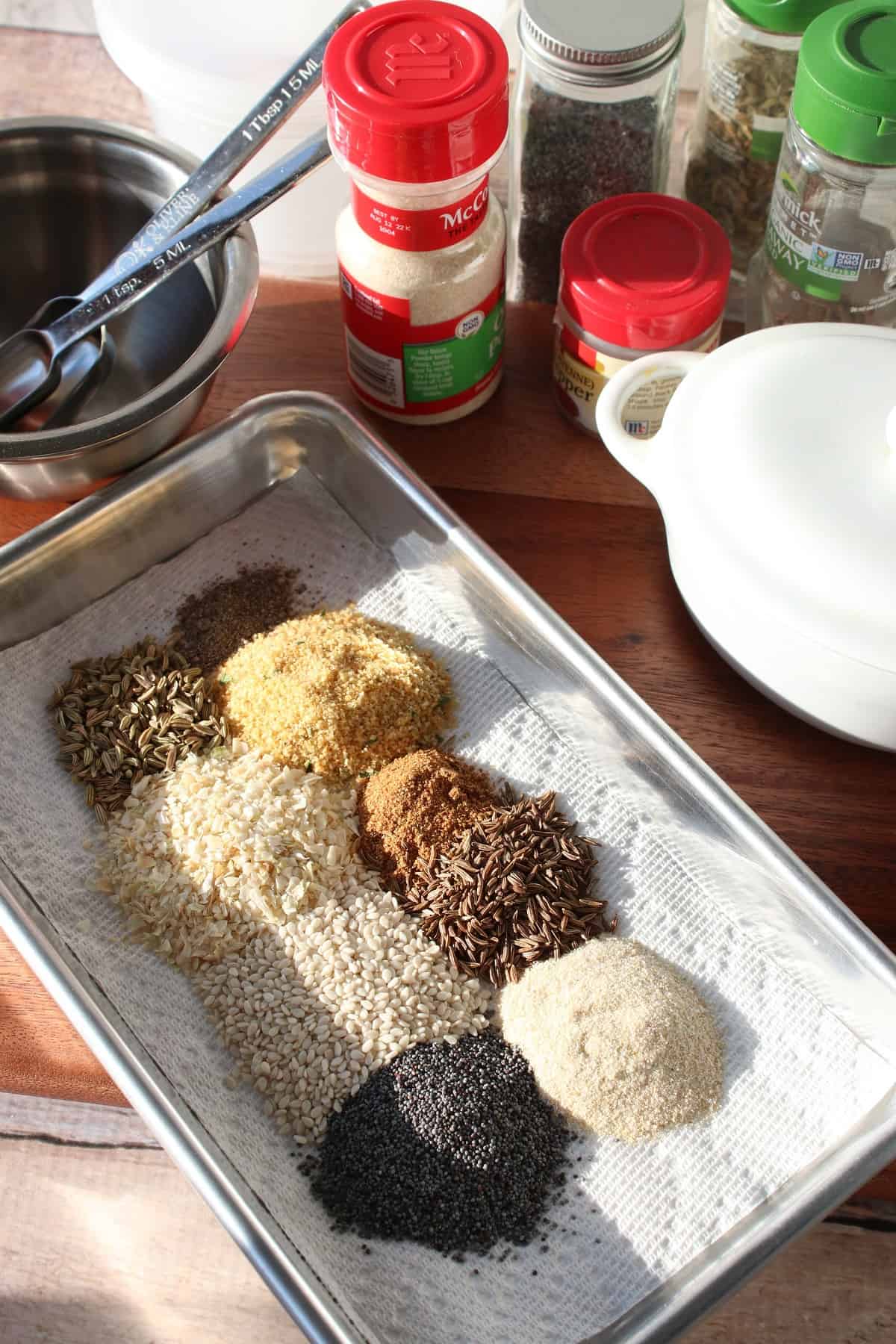 An overhead photos of a small baking sheet with piles of spices and seasonings on it.
