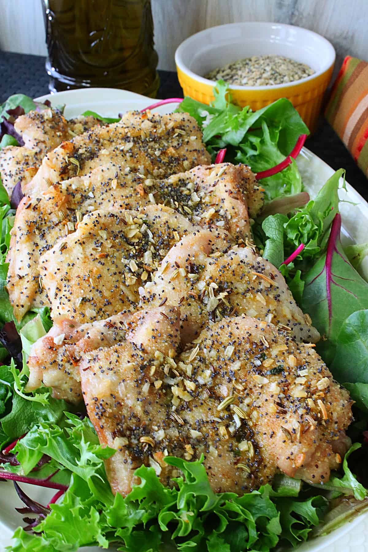 Golden baked chicken thighs topped with everything seasoning on a platter.