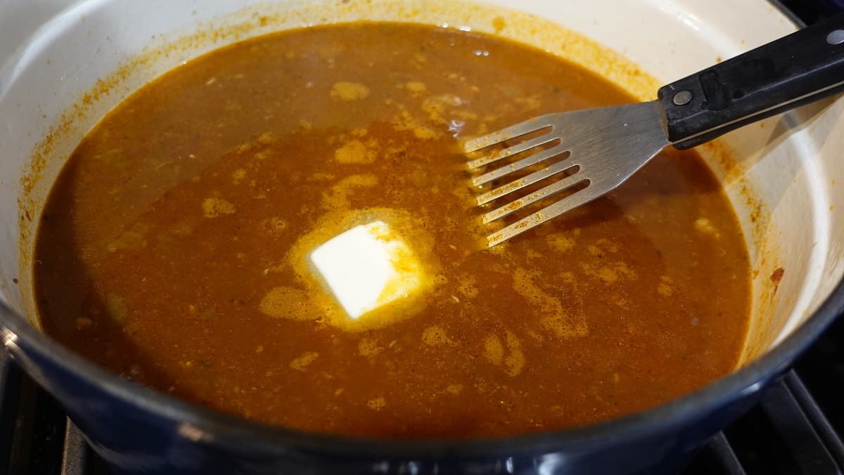 A pat of melting butter in a pot of soup.