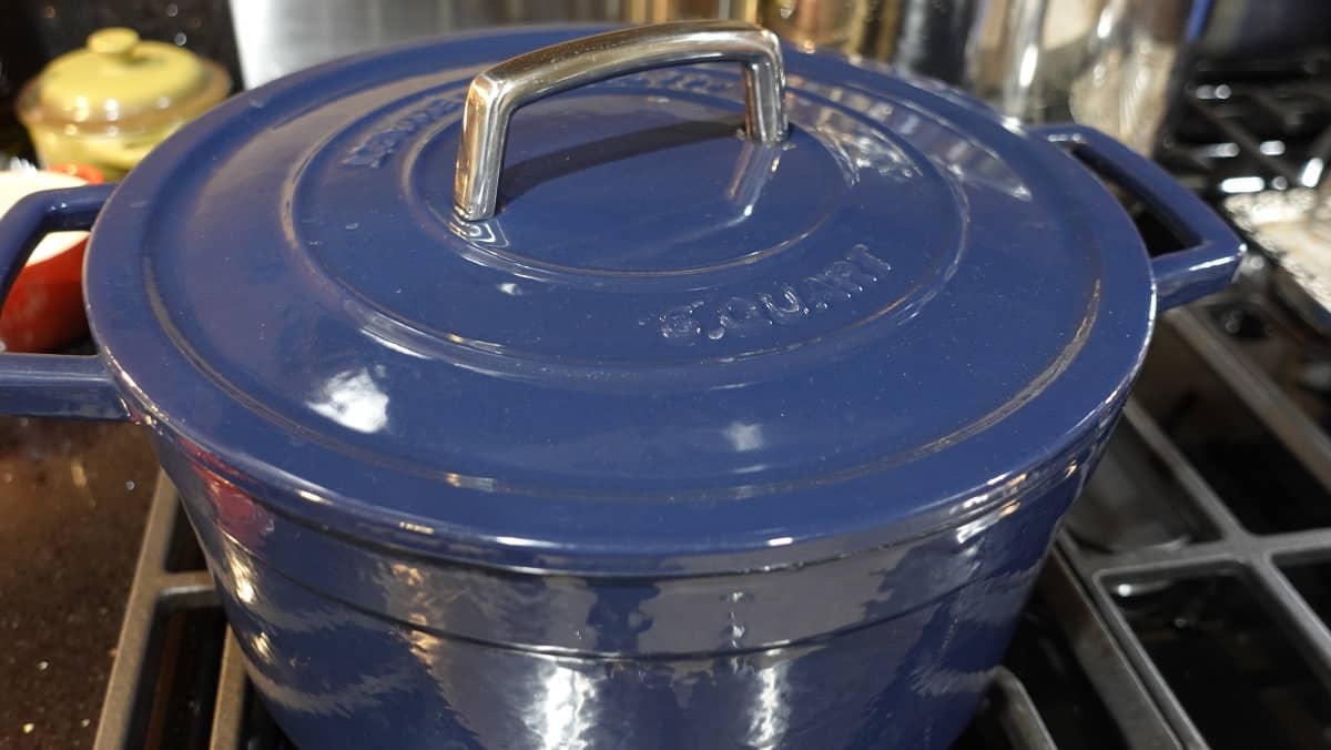 A blue Dutch oven on the stovetop with the lid on.