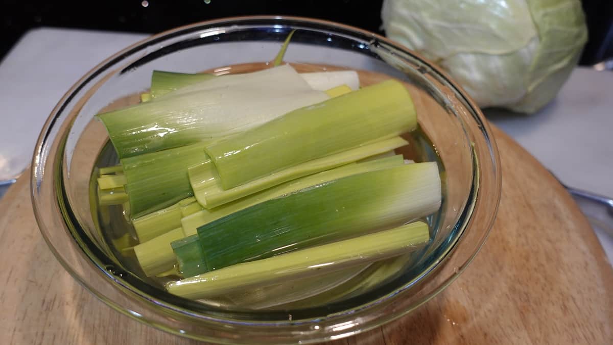 Image of cut leeks in a bowl of water being washed.