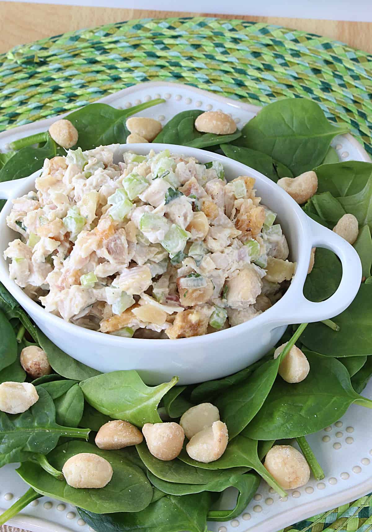 Delicious Hawaiian Chicken Salad in a small white casserole dish on a bed of spinach leaves.