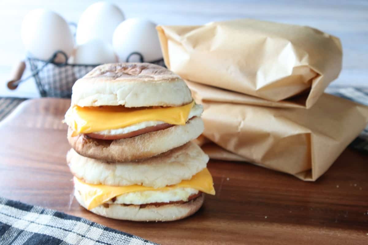 Two stacked Air Fryer Egg McMuffins on a wooden board. 