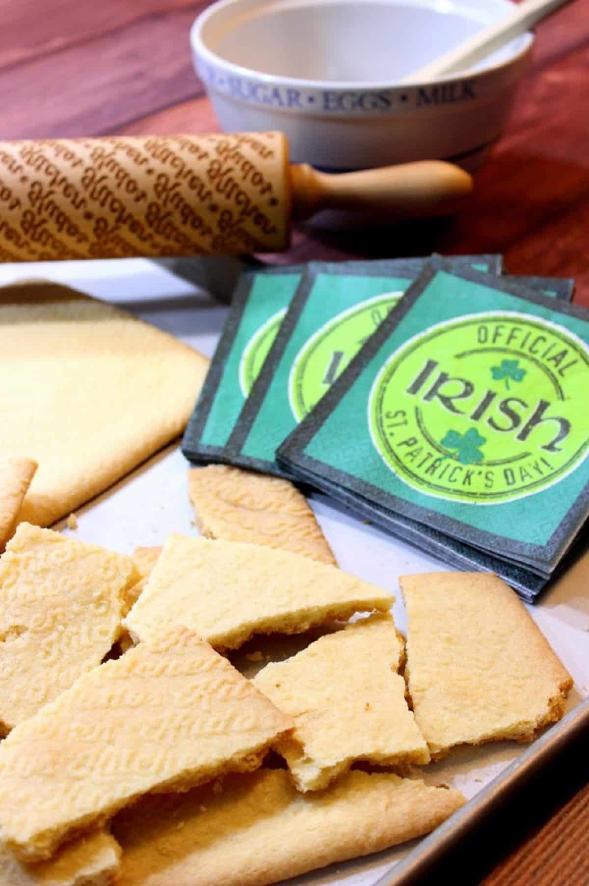 Broken and baked Irish Shortbread Cookies on a baking sheet with napkins.