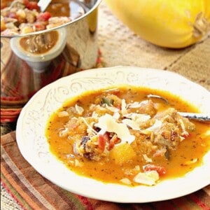 A white bowl filled with Spaghetti Squash Soup with a spoon.