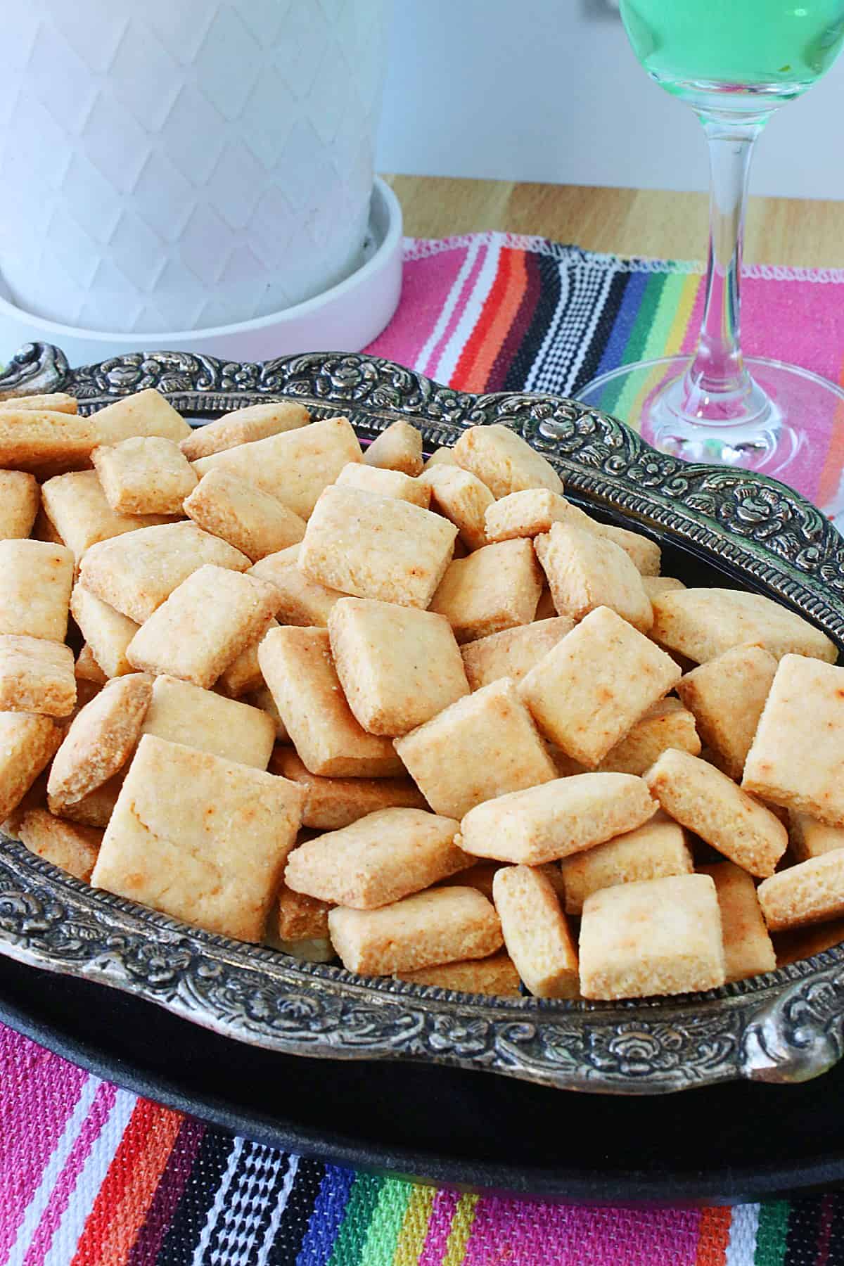A bunch of square homemade crackers in a pretty metal dish.
