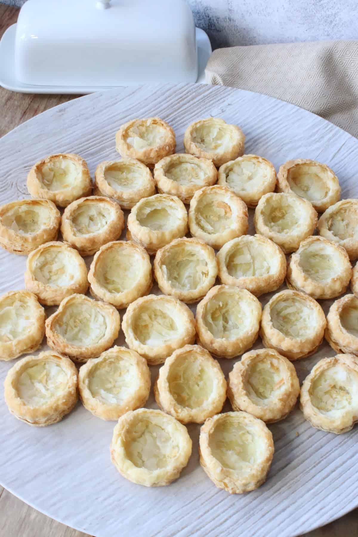 A round plate filled with homemade puff pastry appetizer cups.