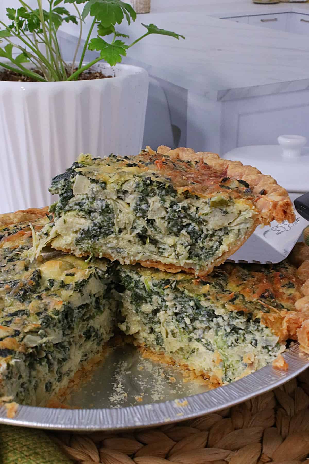 An inside look of a Spinach and Artichoke Quiche slice.