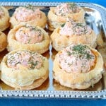 Pretty Ham and Cheese Puff Pastry Appetizer Cups topped with dill on a pretty silver platter.