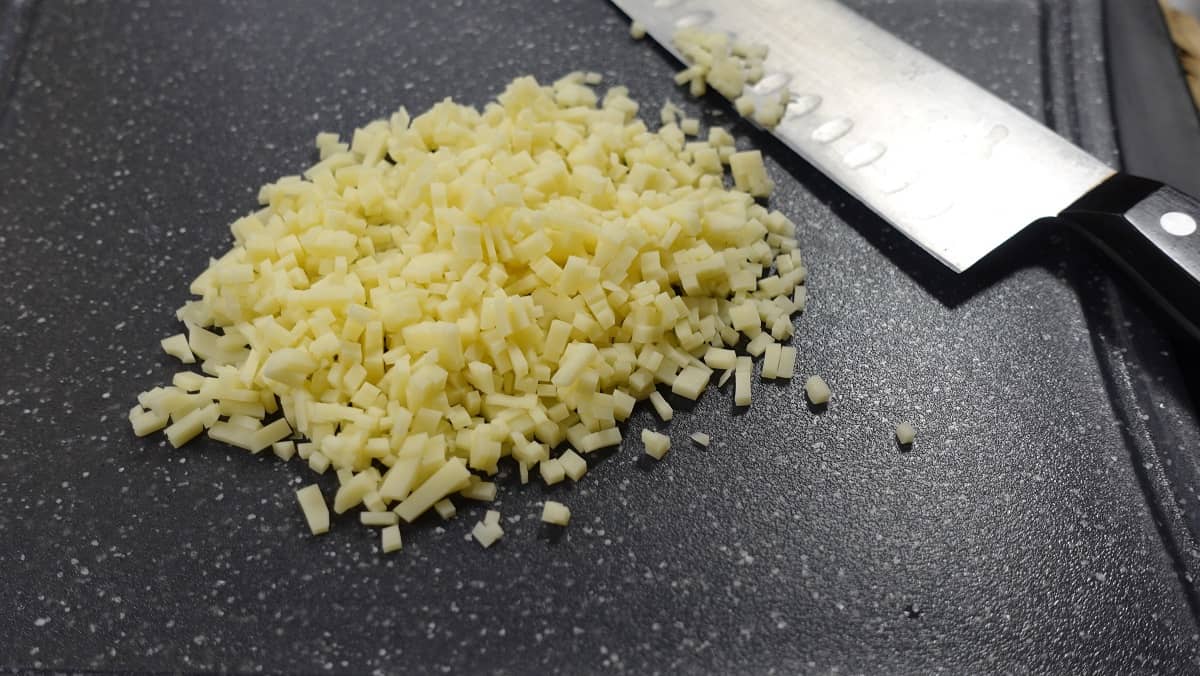 A pile of Swiss cheese that has been diced into a very small size.