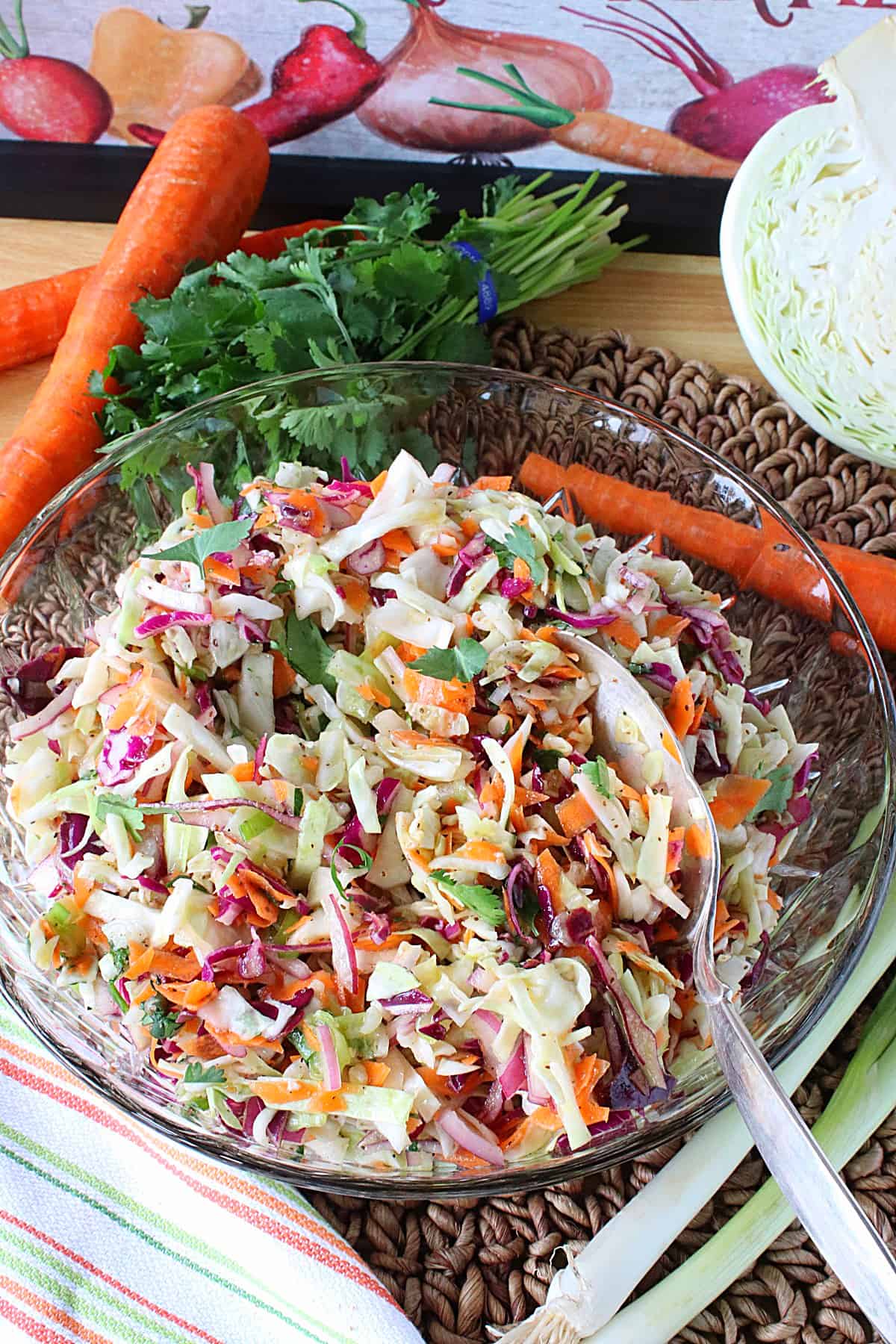 A glass bowl filled with a colorful No Mayo Sweet Sour Coleslaw with carrots and shredded cabbage.